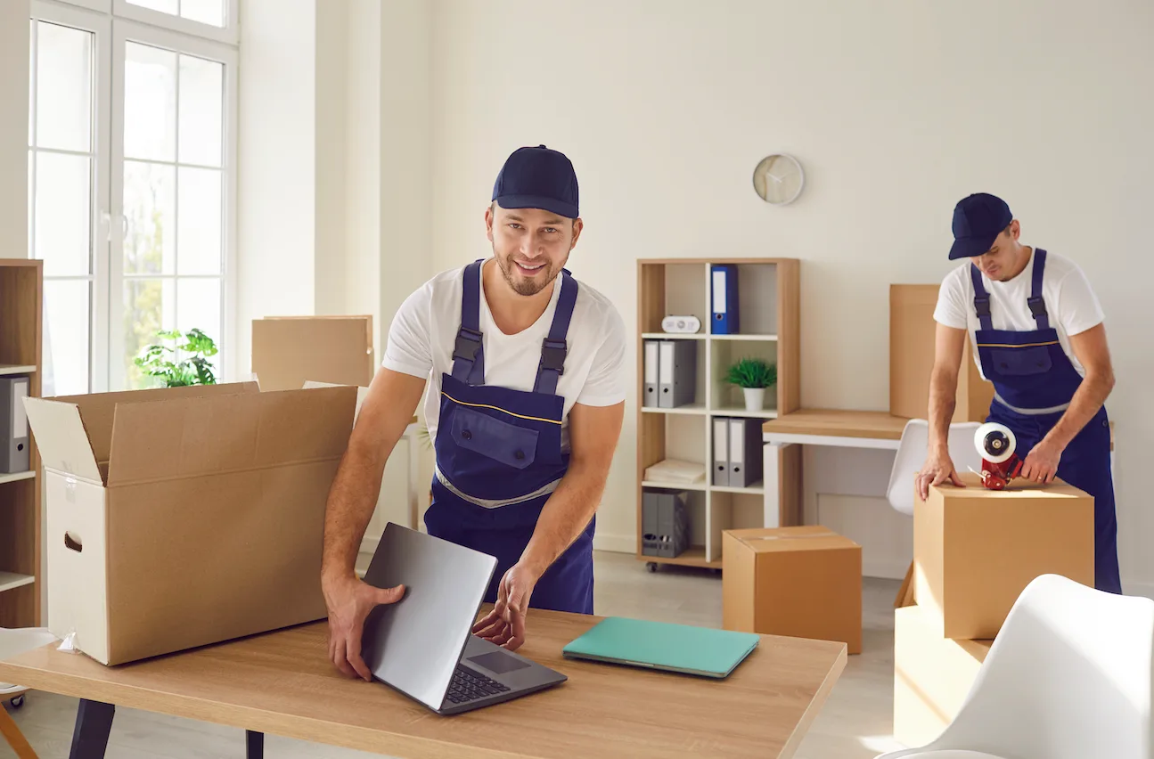 Two In A Zip Moving crew members in branded caps and shirts, one reaching out to shake hands