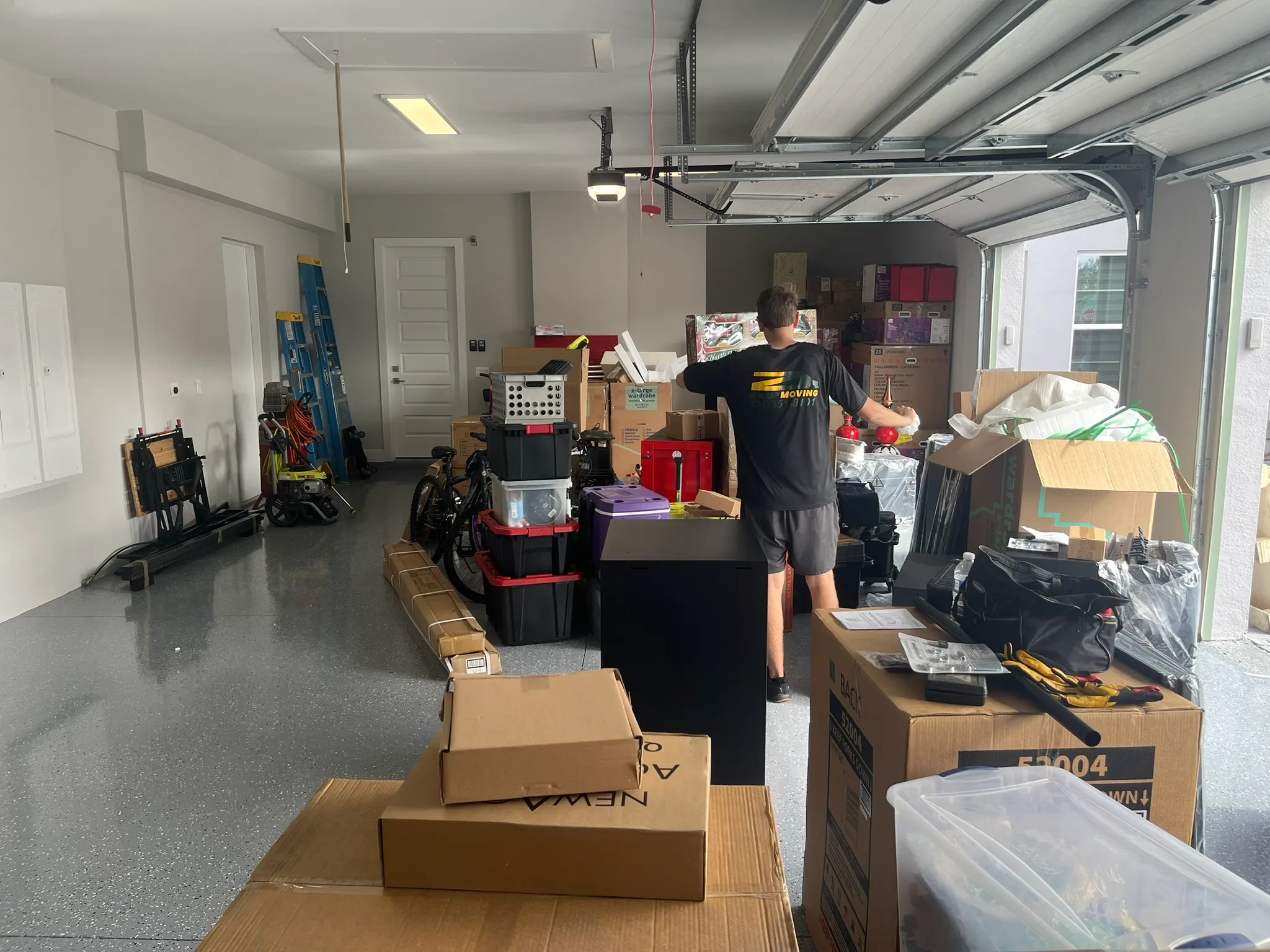 An In A Zip Moving crew member organizing boxes in a packed garage